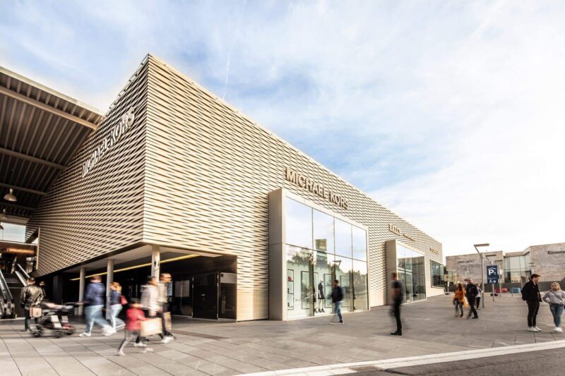 Moderne Architektur eines Geschäftsgebäudes mit Menschen im Vordergrund.