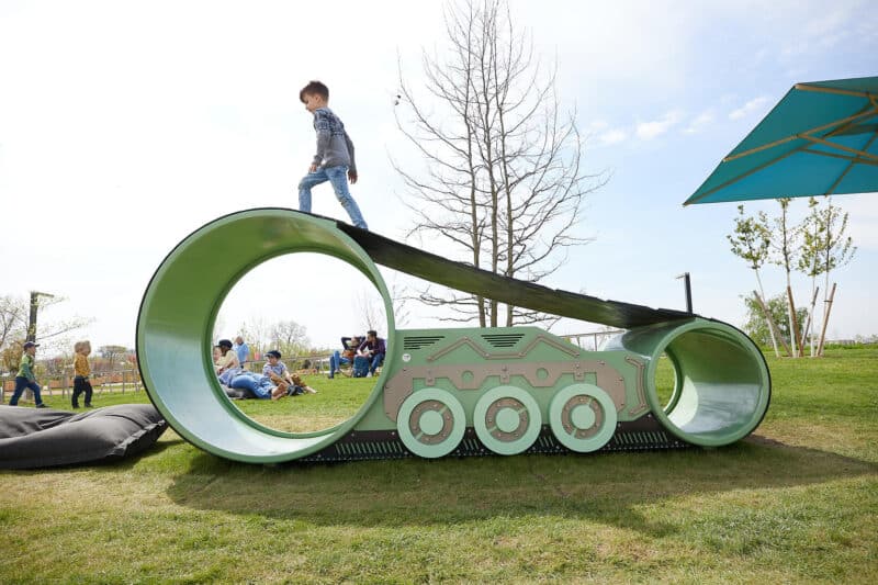 Kind balanciert auf einem Spielgerät in einem Park.