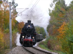 Dampflok 58 311 fährt durch eine herbstliche Landschaft.