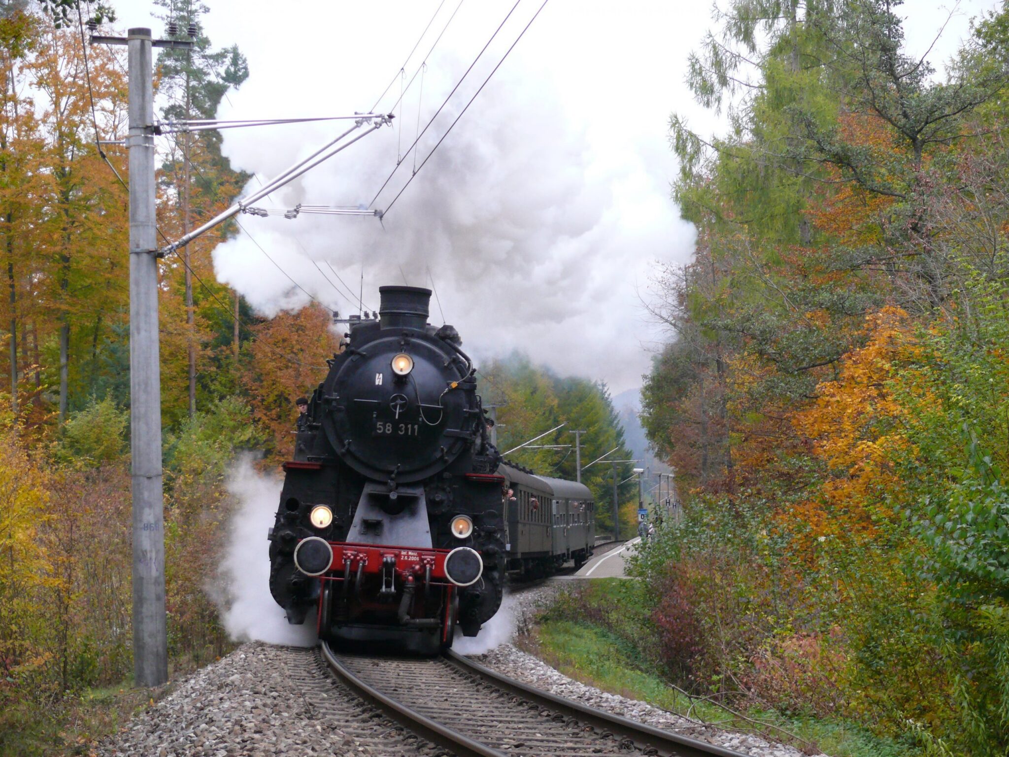 Dampflok 58 311 fährt durch eine herbstliche Landschaft.