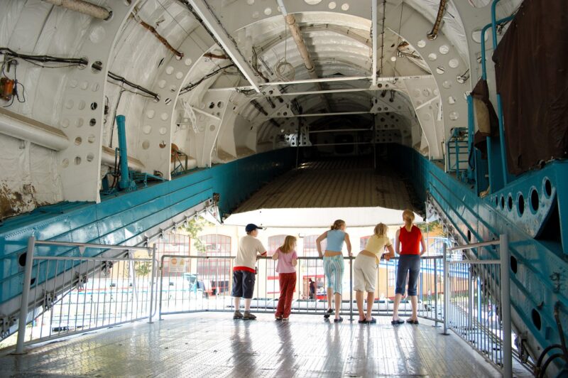 Familie schaut in ein großes, leeres Flugzeuginnere.