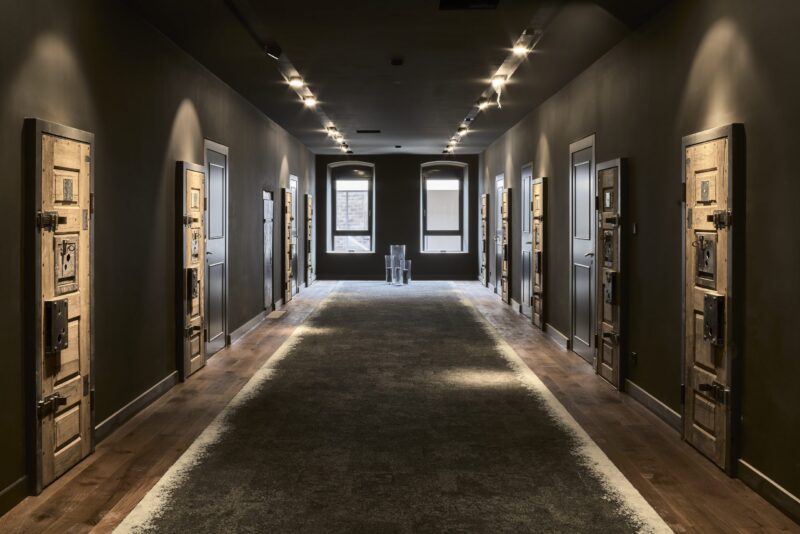 Dunkler Flur mit mehreren Türen und Fenstern.