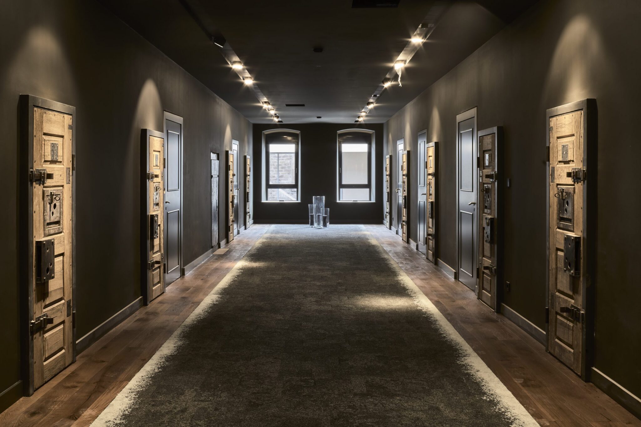 Dunkler Flur mit mehreren Türen und Fenstern.