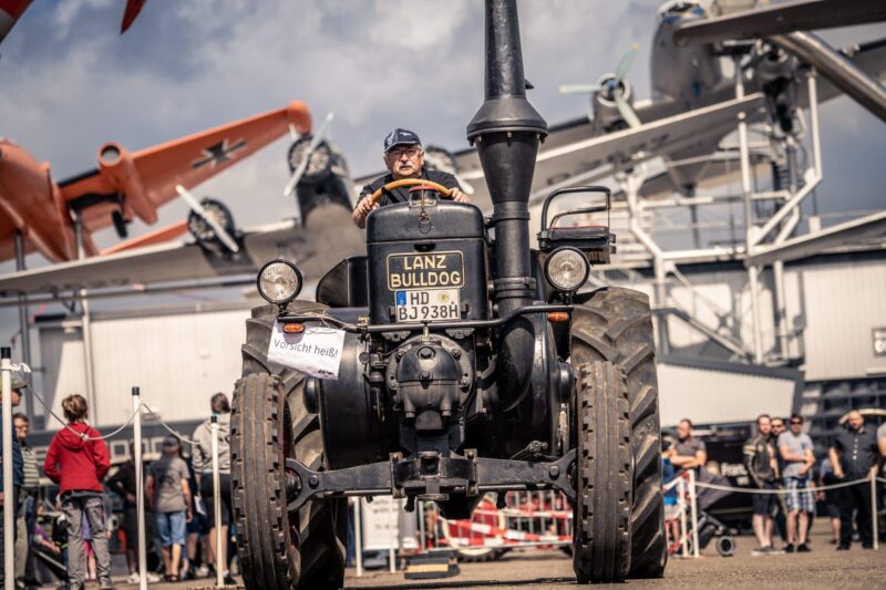 Mann fährt einen alten Lanz Bulldog Traktor auf einer Veranstaltung.