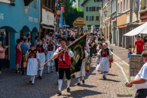 Traditioneller Umzug mit Trachtenträgern und Fahnen in einer belebten Straße.