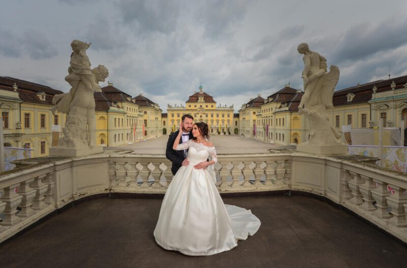 Hochzeitsfoto eines Paares vor einem historischen Gebäude.