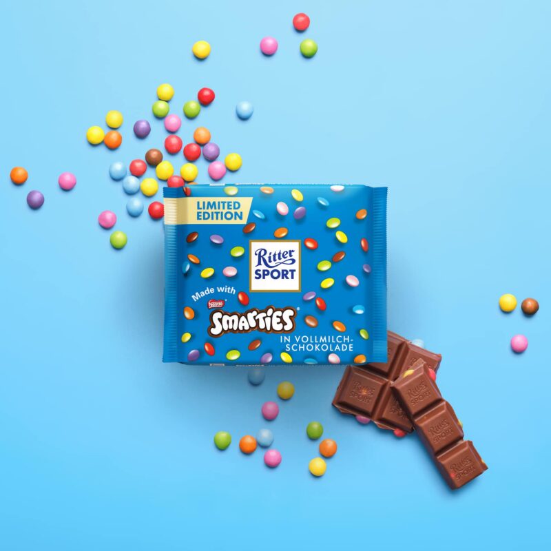 Ritter Sport Schokolade mit Smarties auf blauem Hintergrund.