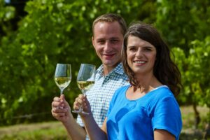 Paar mit Weingläsern in einem Weinberg.