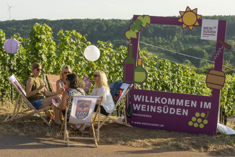 Vier Frauen sitzen in einem Weinberg und genießen die Zeit.