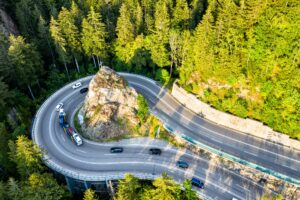 Luftaufnahme einer kurvigen Straße mit Felsen und Bäumen.