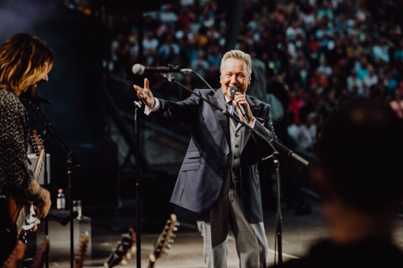 Mann im Anzug singt auf einer Bühne vor Publikum.