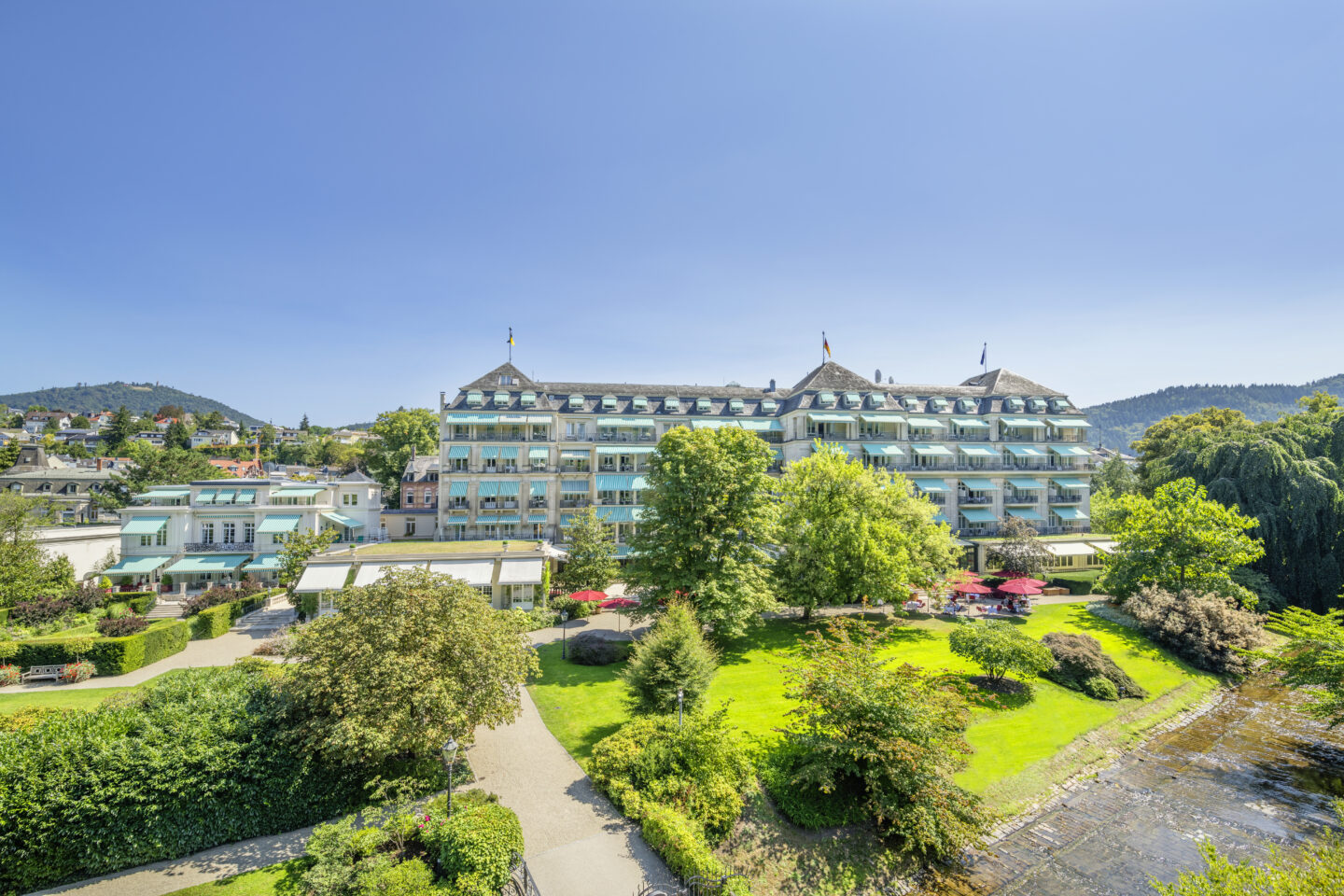 Ansicht eines eleganten Hotels mit Garten und blauen Himmel.