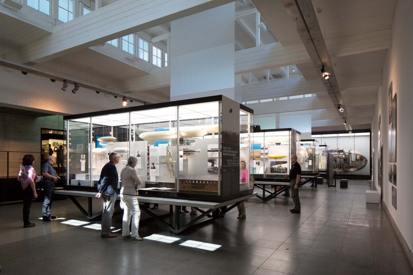 Besucher im Museum betrachten Ausstellungsstücke in Vitrinen.