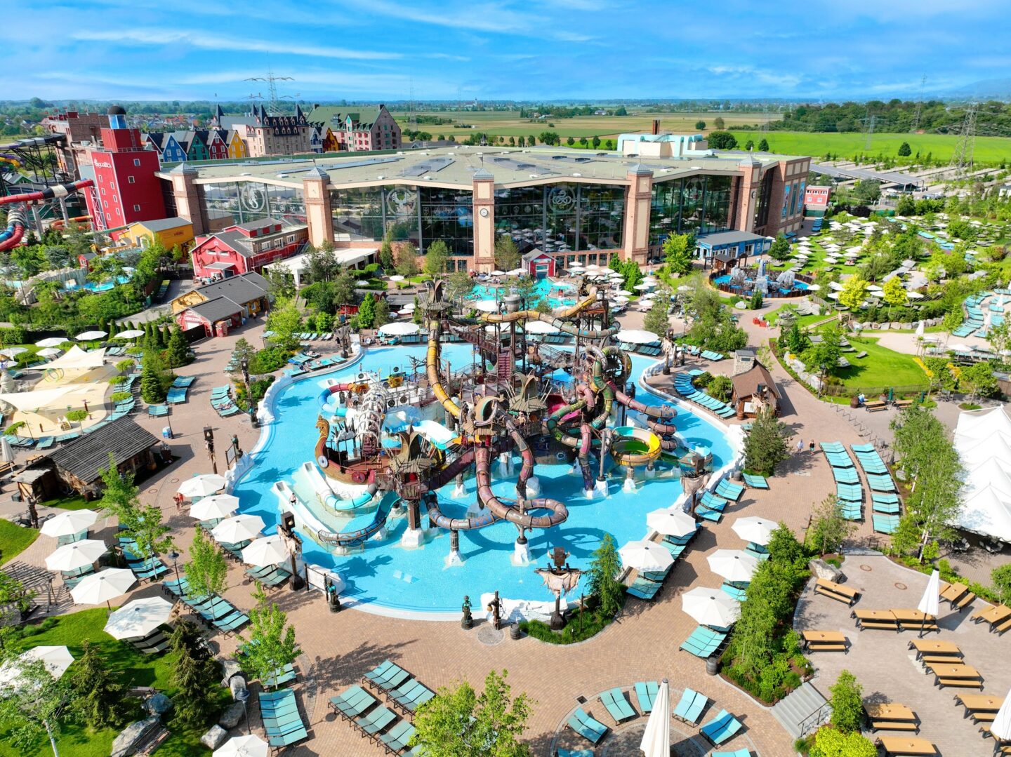 Blick auf einen Wasserpark mit Rutschen und Liegen.