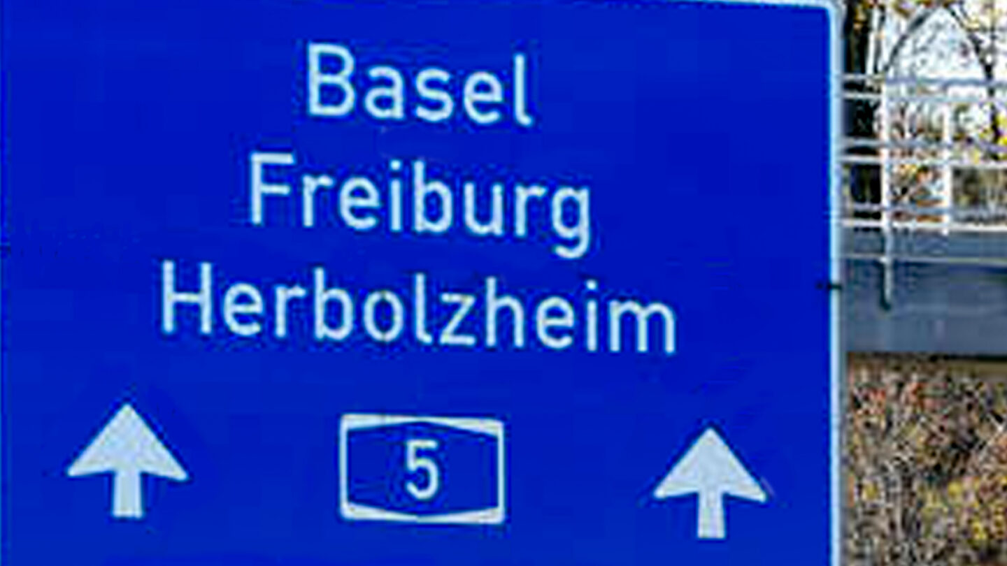 Verkehrsschild mit Richtungshinweisen nach Basel, Freiburg und Herbolzheim.