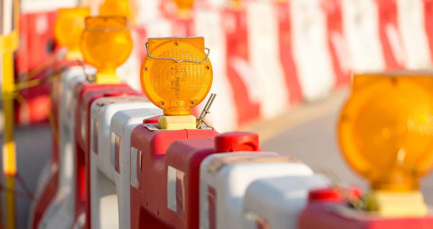Bauarbeiten mit orangefarbenen Warnleuchten auf einer Baustelle.
