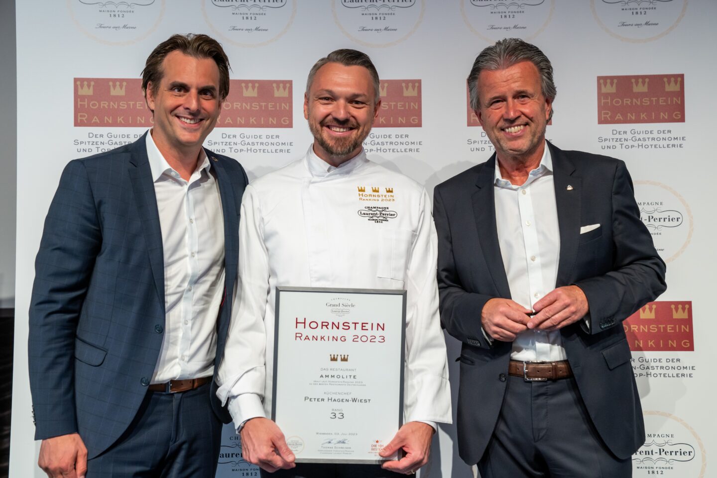 Drei Männer posieren mit einer Auszeichnung beim Hornstein Ranking 2023.