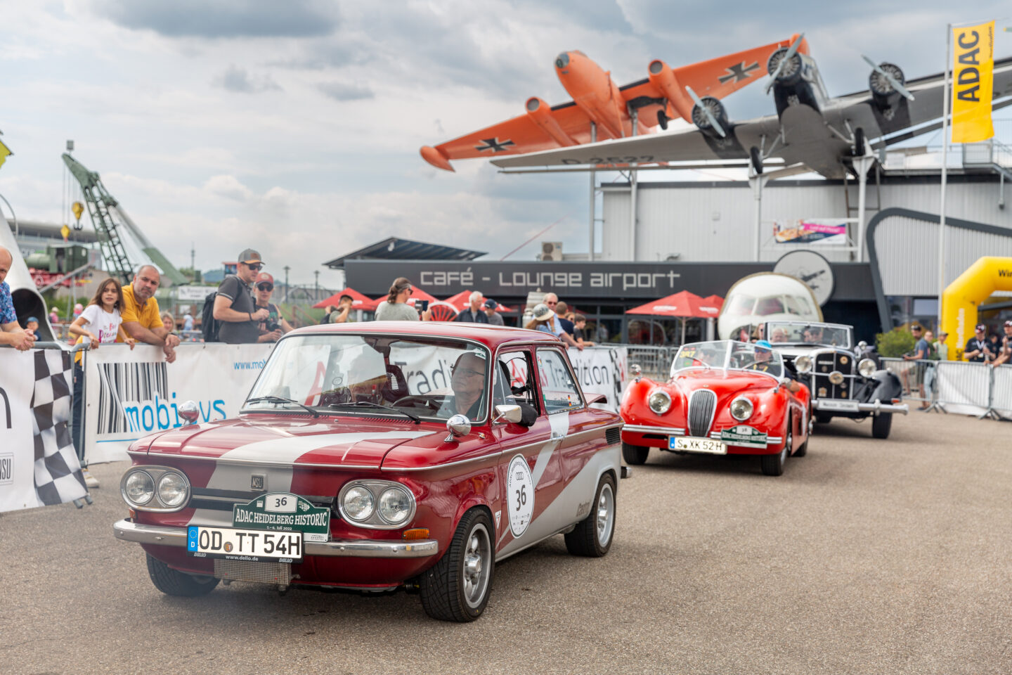 Oldtimer-Rallye mit mehreren klassischen Autos und Zuschauern.