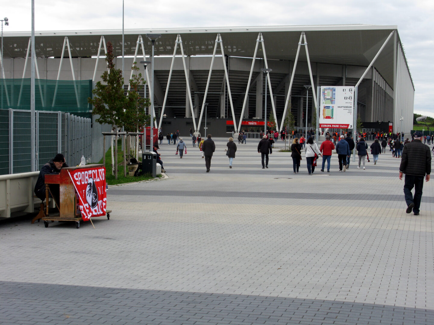 Menschenmenge vor einem modernen Stadion mit einem Banner.