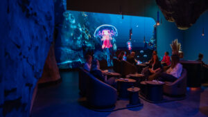Moderne Lounge mit Projektion von Quallen im Hintergrund.