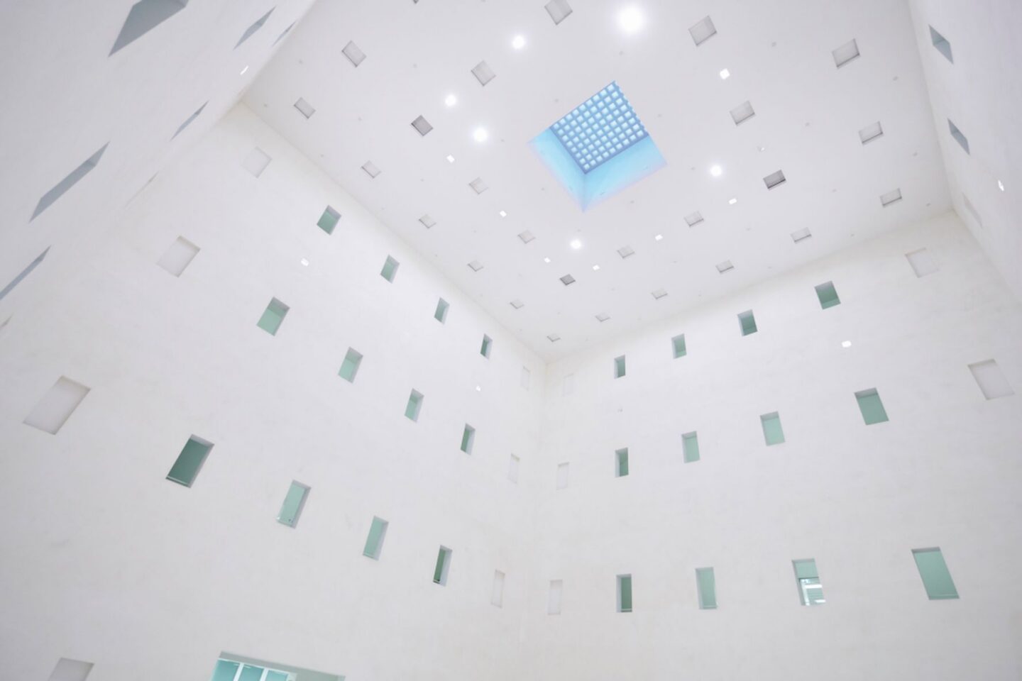 Heller Innenraum mit weißen Wänden und quadratischem Oberlicht.