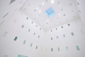 Heller Innenraum mit weißen Wänden und quadratischem Oberlicht.