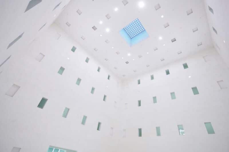 Heller Innenraum mit weißen Wänden und quadratischem Oberlicht.