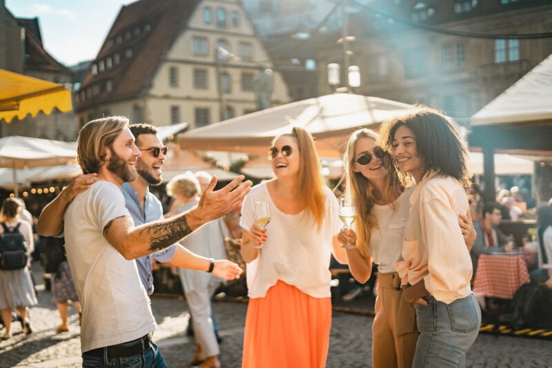 Gruppe von Freunden lacht und feiert auf einem Markt.