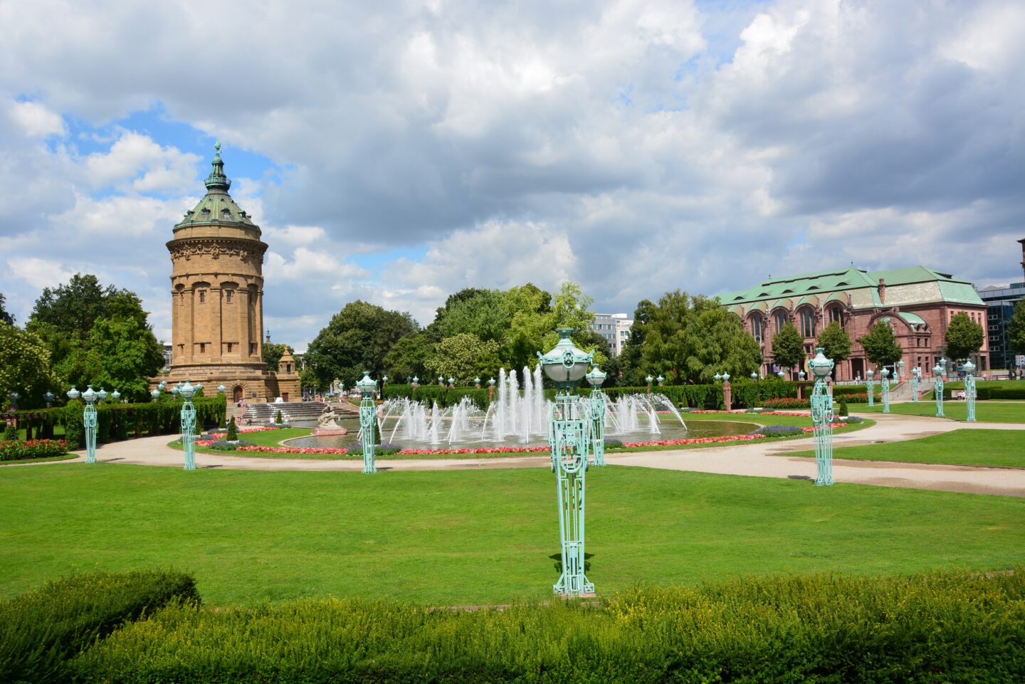 Schöner Park mit Brunnen und historischem Gebäude im Hintergrund.