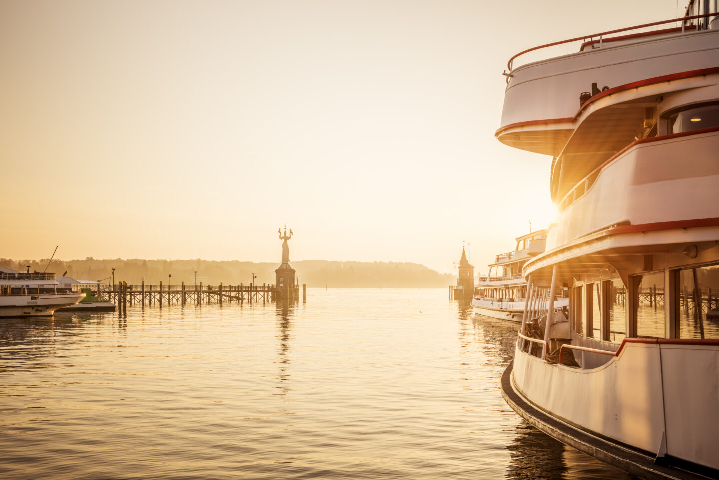 Hafenansicht mit Booten und Sonnenuntergang über dem Wasser.
