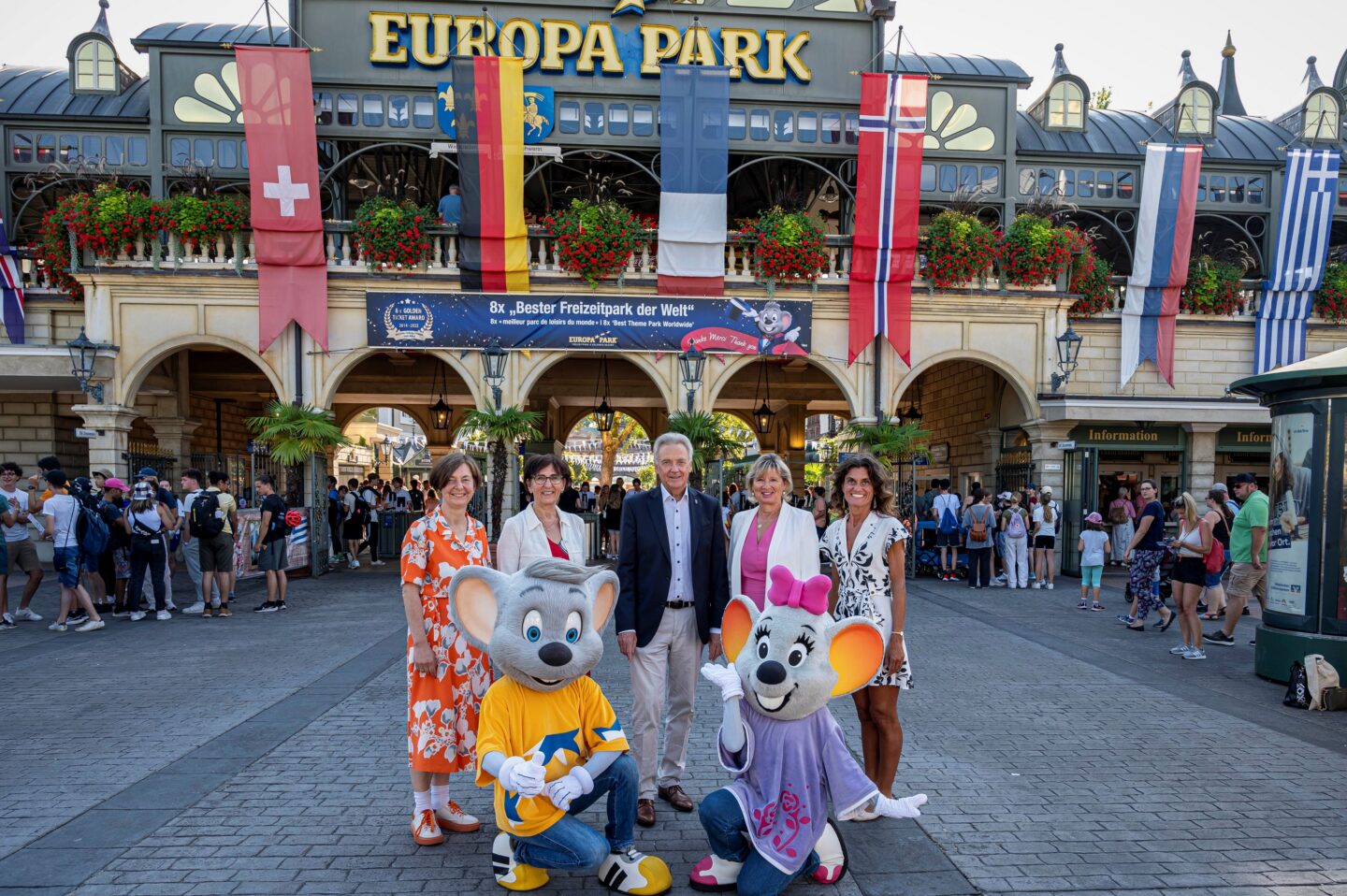Gruppe von Menschen und Maskottchen vor dem Europa Park Eingang.