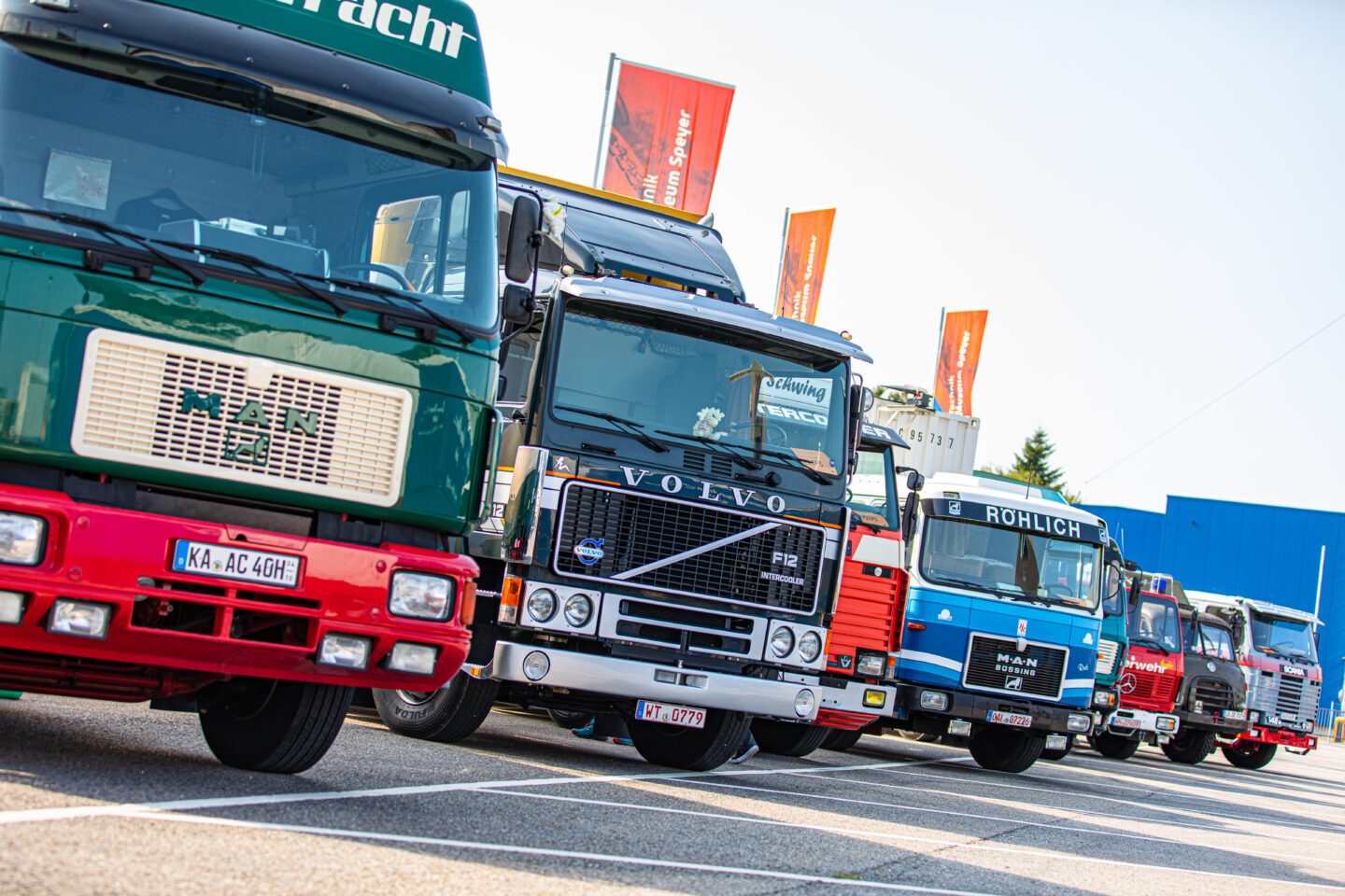 Reihe von Lkw verschiedener Marken auf einem Parkplatz.