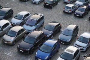 Verschiedene Autos auf einem Parkplatz mit Pflastersteinen.