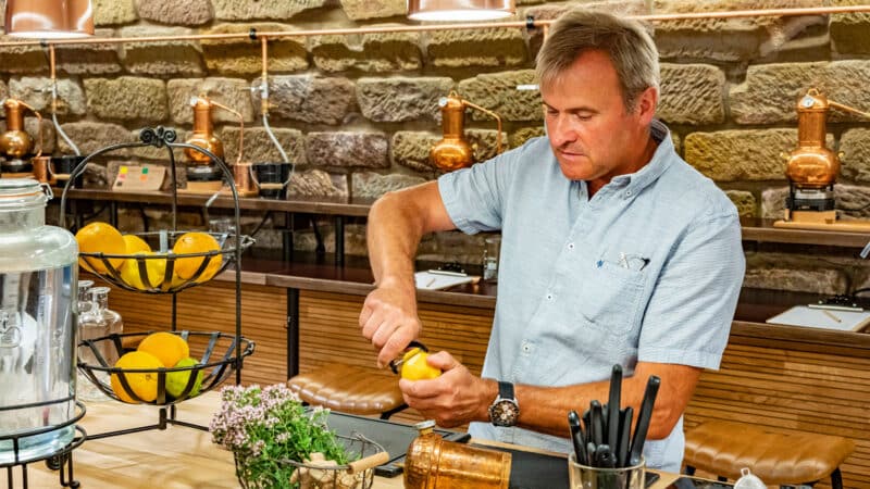 Mann schält eine Zitrone in einer modernen Destillerie.