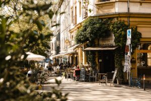 Gemütliche Straßenszene mit Cafés und Gästen im Freien.