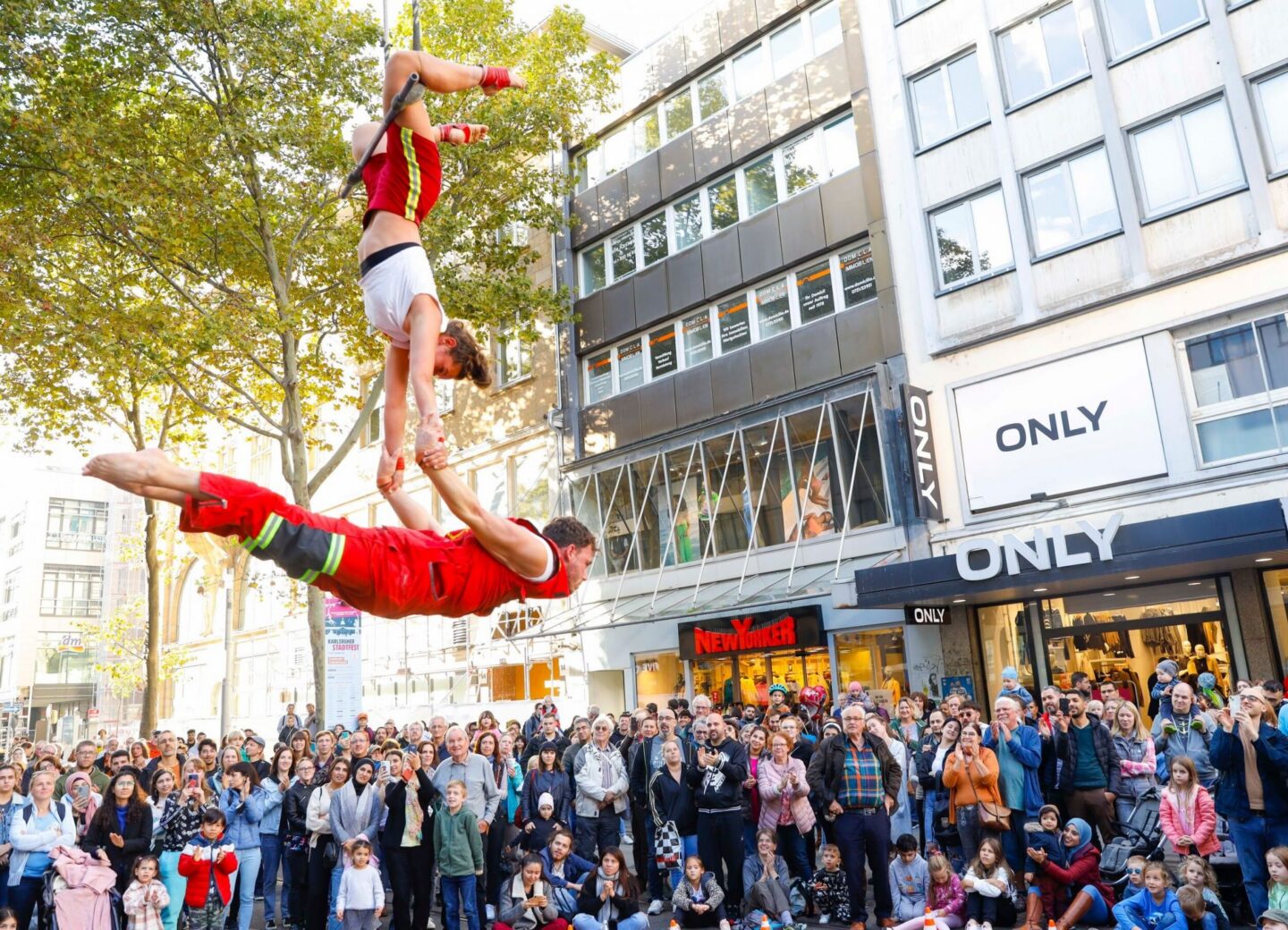 Zwei Artisten führen eine akrobatische Darbietung in der Stadt auf.