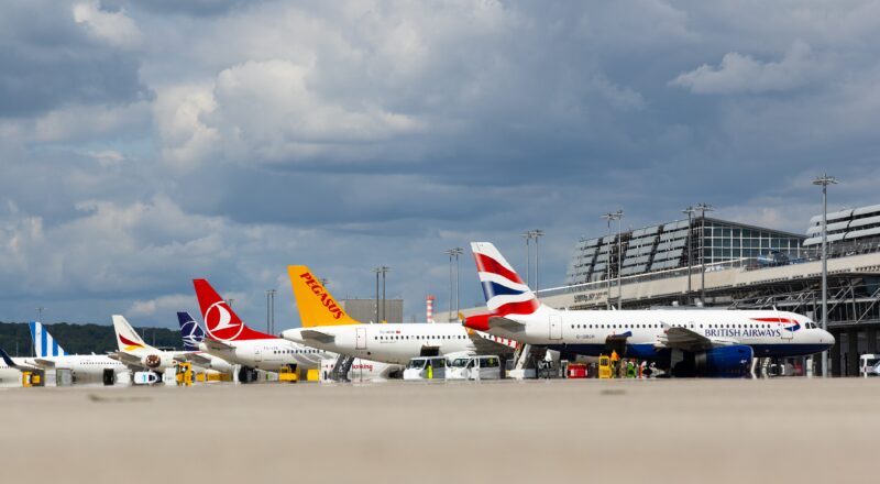 Flughafen mit mehreren Flugzeugen verschiedener Airlines auf dem Rollfeld.