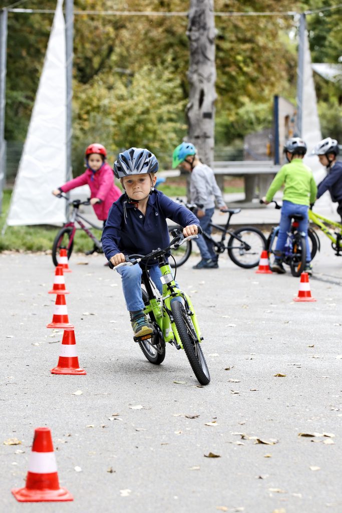 Kinder testen die Fahrräder im Slalomparcours
