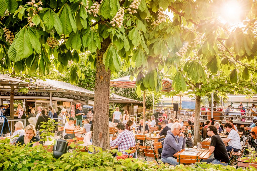 Der Biergarten der Hafenhalle bietet eine idyllische Atmosphäre mit Blick auf den Yachthafen – perfekt für einen entspannten Nachmittag.
