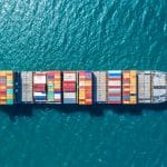 Ein großes Containerschiff auf dem offenen Meer, beladen mit farbigen Containern