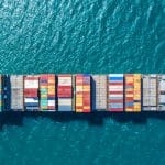 Ein großes Containerschiff auf dem offenen Meer, beladen mit farbigen Containern