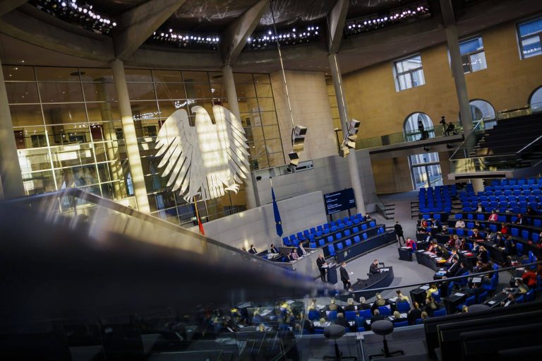Die tief stehende Sonne beleuchtet den Plenarsaal. Blick auf den Bundestagsadler. Blick ins Plenum.