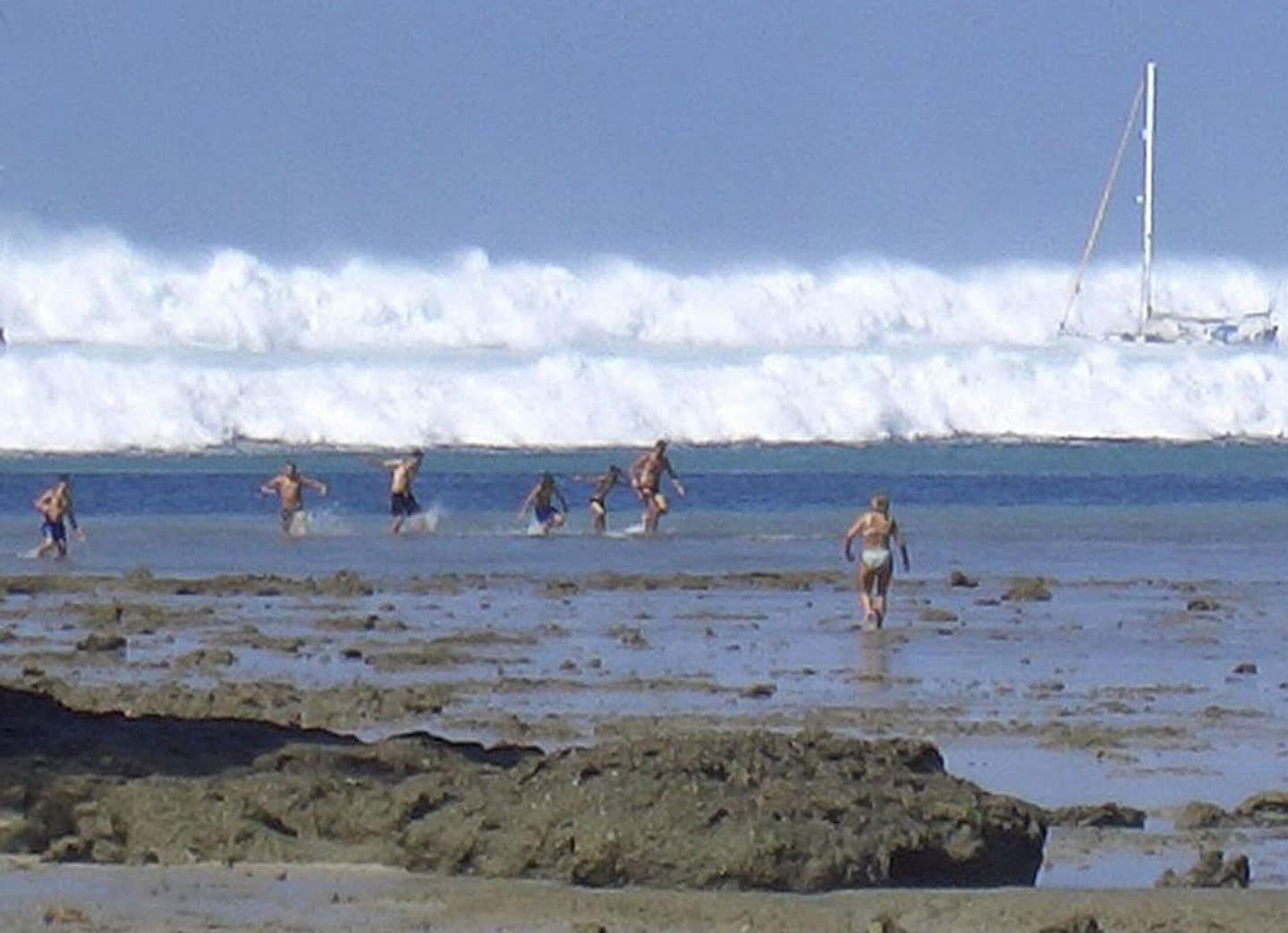"Überlebt! Tsunami 2004": Menschen fliehen vor heranrasenden Wellen, die im Hintergrund brechen.