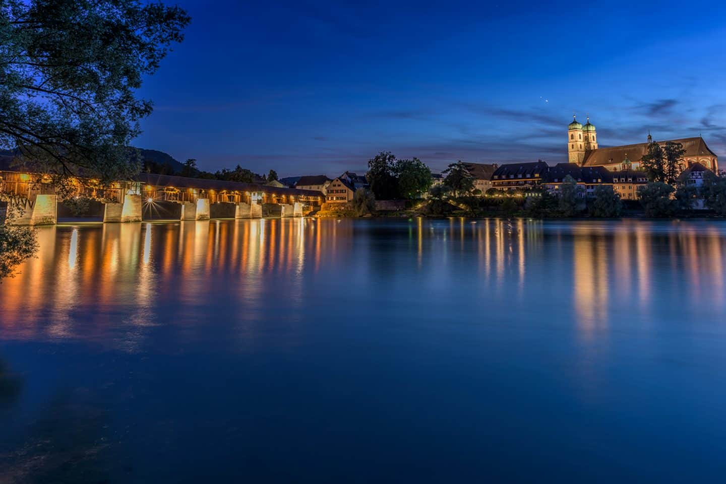 Blick auf das Münster Bad Säckingen und die längste gedeckte Holzbrücke Europas, die über den Rhein führt und Deutschland und die Schweiz miteinander verbindet
