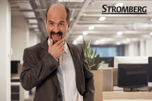 Christoph Maria Herbst in seiner Rolle als Stromberg, humorvoll posierend in einem modernen Büro. Im Hintergrund ist der Schriftzug "Stromberg" zu sehen, der die bekannte Comedy-Serie repräsentiert.