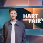 Louis Klamroth, Moderator der ARD-Talkshow „hart aber fair“, steht vor dem Studiohintergrund mit dem Sendungslogo.
