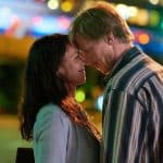 Szene aus „Eine Liebe später“: Eine Frau (Lucie Heinze) und ein Mann (Golo Euler) stehen sich in der Nacht in einer Stadt gegenüber, Stirn an Stirn, mit leuchtenden Lichtern und verschwommenem Hintergrund.