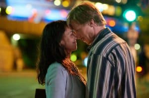 Szene aus „Eine Liebe später“: Eine Frau (Lucie Heinze) und ein Mann (Golo Euler) stehen sich in der Nacht in einer Stadt gegenüber, Stirn an Stirn, mit leuchtenden Lichtern und verschwommenem Hintergrund.