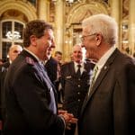Ministerpräsident Winfried Kretschmann im Gespräch mit Einsatzkräften bei einem Empfang in einem festlichen Saal mit historischen Verzierungen. Im Hintergrund weitere Gäste, darunter Personen in Uniform.