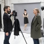 "Die Chefin - True Crime": In einem weißen Fotostudio befragt Vera Lanz (Katharina Böhm) den schwarz gekleideten Fotografen Ulf Brandt (Thomas Wodianka). Er hat eine Hand an seiner Kamera, die auf einem Stativ steht und auf eine ausgerollte graue Leinwand gerichtet ist. Dort steht eine Schaufensterpuppe mit verschränkten Armen, gekleidet in ein kurzes schwarzes Kleid und eine schwarze Baskenmütze.